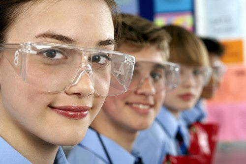students in lab safety glasses looking into the camera and smiling