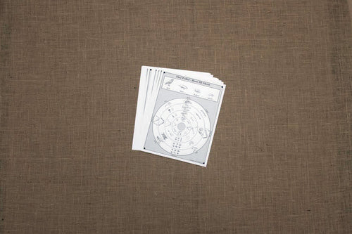 A single white bone sorting sheet with printed text and illustrations placed on a brown surface.