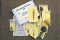 An educational crop identification kit with various packaged seeds and samples spread out on a table, along with a guidebook.