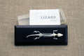 a skeleton of a lizard displayed with a clear acrylic cover and label saying "LIZARD Skeleton"