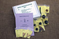 An open seed identification kit box displaying various seeds, seed cards, and a key for identifying the seeds.