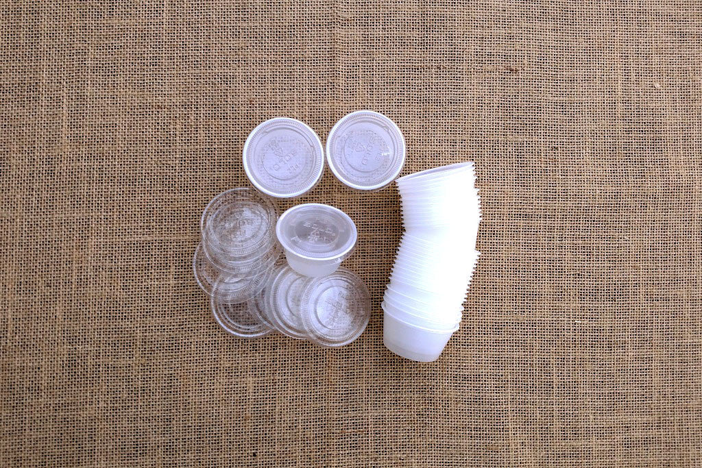 Small clear plastic animal bone containers with lids, displayed on a textured background.